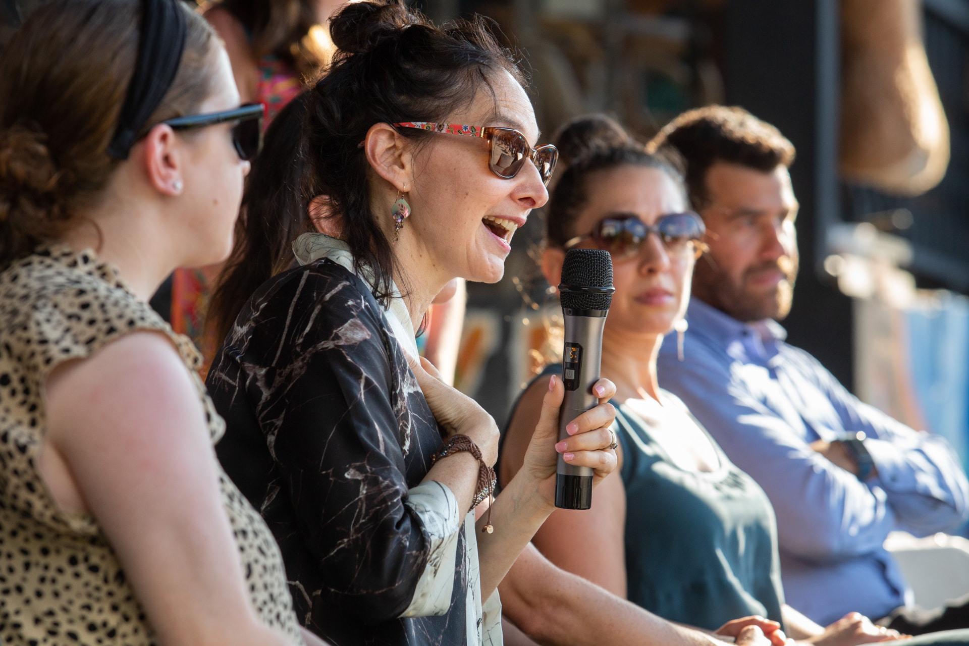 Panelist speaking into a microphone at an outdoor forum